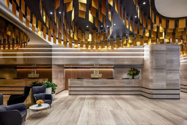 Recepción moderna con techo decorativo dorado en el Meriton Suites Pitt Street de Sídney