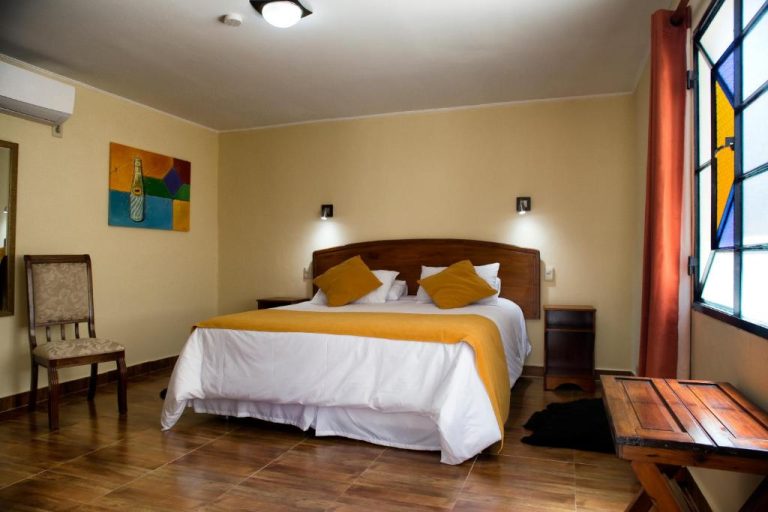 Habitación doble con cama matrimonial y decoración acogedora en Hotel FK Paso de los Toros Boutique