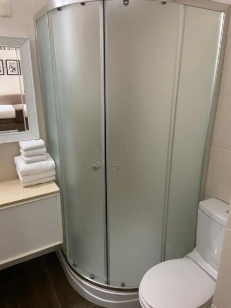 Baño moderno con cabina de ducha redonda de cristal esmerilado en Hotel Alvear