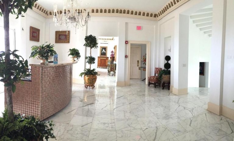 Elegante lobby con suelo de mármol y araña de cristal en Ocean West Boutique Hotel