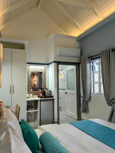 Habitación doble con techo de madera, cama king y mini cocina en Villa Charme de L'ile