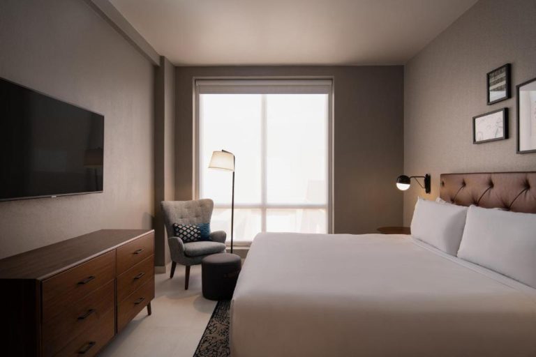 Habitación king con cama doble, TV y sillón en Four Points by Sheraton Puntacana