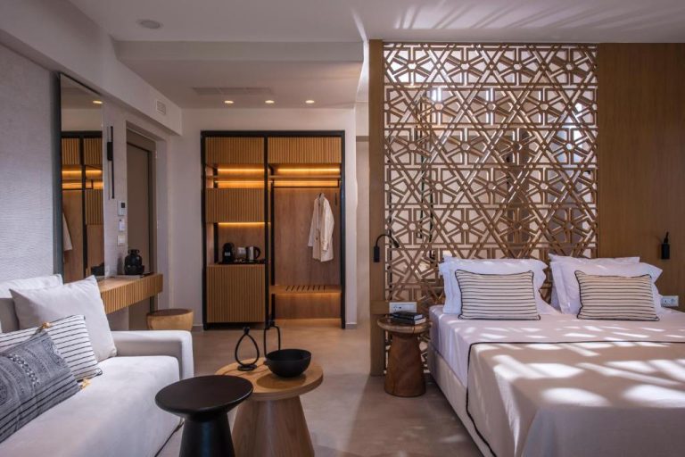 Suite de lujo con cama doble y panel decorativo de madera tallada en Niriides Palace