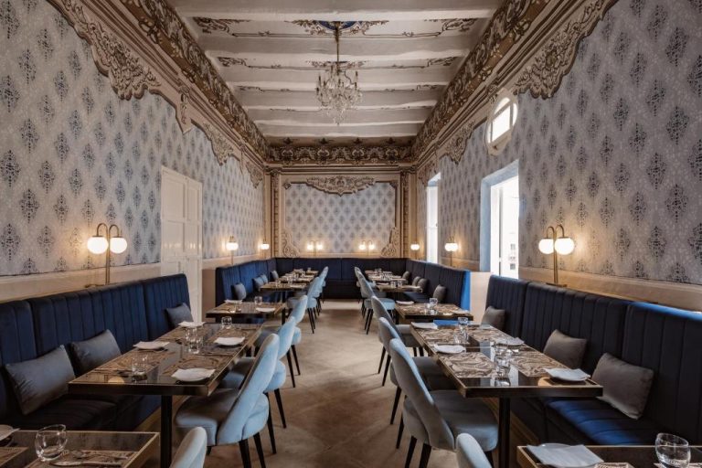 Elegante restaurante con decoración barroca y tapicería azul en Palazzo Castagna Boutique Hotel