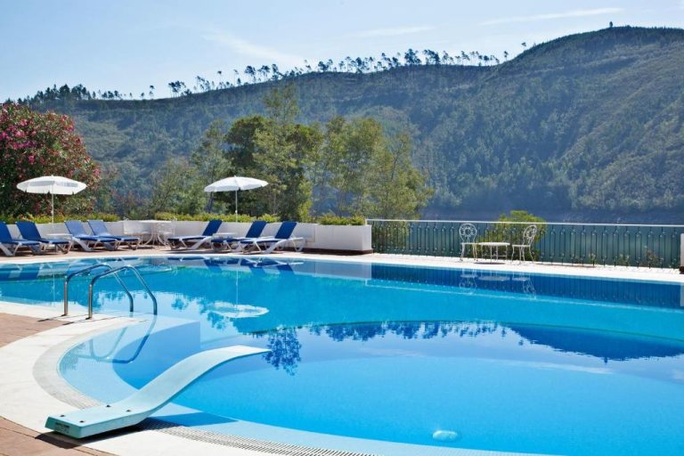 Piscina exterior con tumbonas y vistas a la montaña del Lago Azul Eco Hotel rodeado de naturaleza