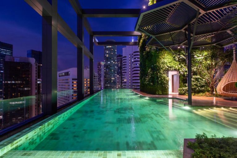 Piscina infinita en la azotea del Hotel Indigo Kuala Lumpur on the Park con vistas al skyline nocturno de la ciudad
