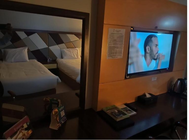 Habitación doble con televisión de pantalla plana y dos camas en el Doha Dynasty Hotel