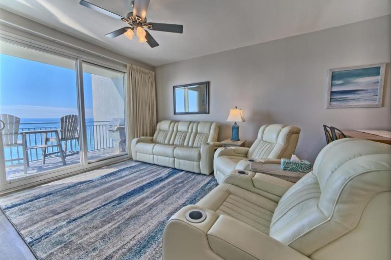 Sala de estar con sofás reclinables de cuero y balcón con vistas al mar en Ocean Front Condo