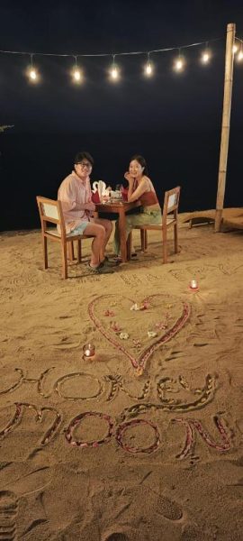 Cena romántica en la playa durante luna de miel en Villa Penyu Gili Trawangan con decoración de flores