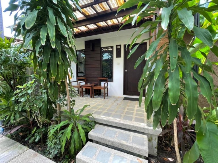 Bungalow número 103 con terraza privada y jardín tropical exuberante en Evergreen Resort