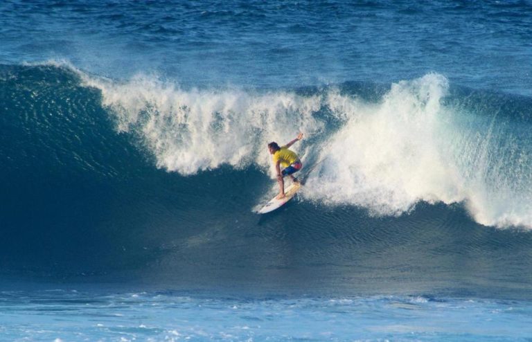 Surfista montando una gran ola en la playa cerca de The Atlantis Historic Inn