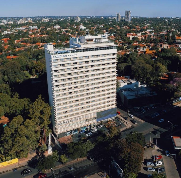 Vista aérea de la fachada exterior del Dazzler by Wyndham Asunción rodeado de vegetación urbana