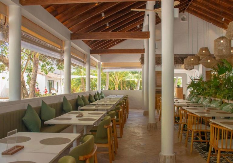 Restaurante interior con vistas a palmeras tropicales y decoración natural en Stone Hotels Dhiffushi Maldivas