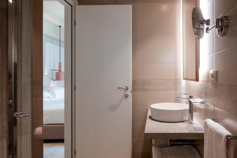 Baño moderno con lavabo sobre encimera y espejo retroiluminado en Mangia's Brucoli Autograph Collection Sicilia