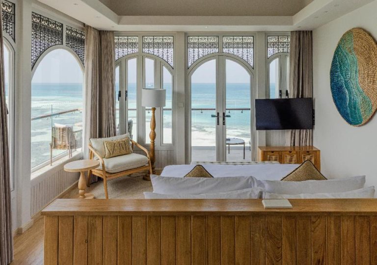 Habitación de lujo con vistas al océano índico y ventanales arqueados en Stone Hotels Dhiffushi