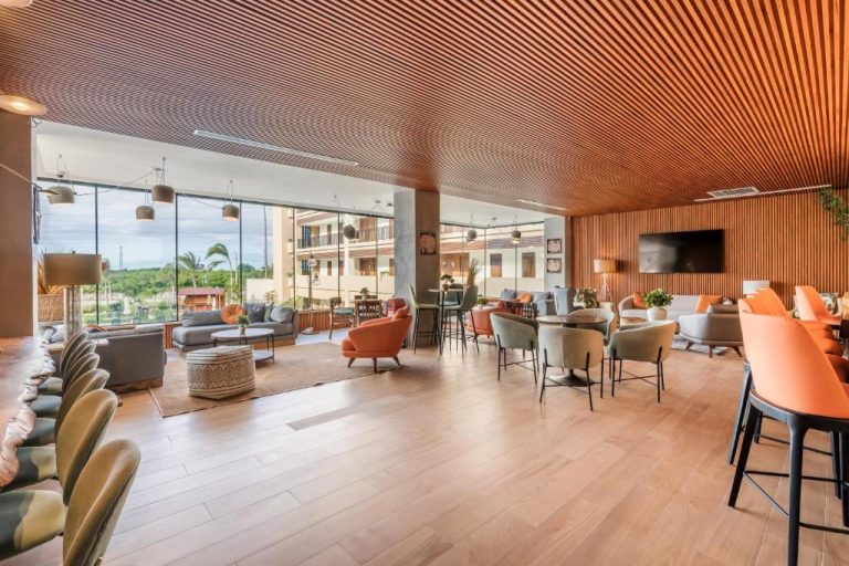 Amplio lobby lounge con mobiliario moderno y techo de madera en Hotel Faranda Single Punta Cana Adults Only