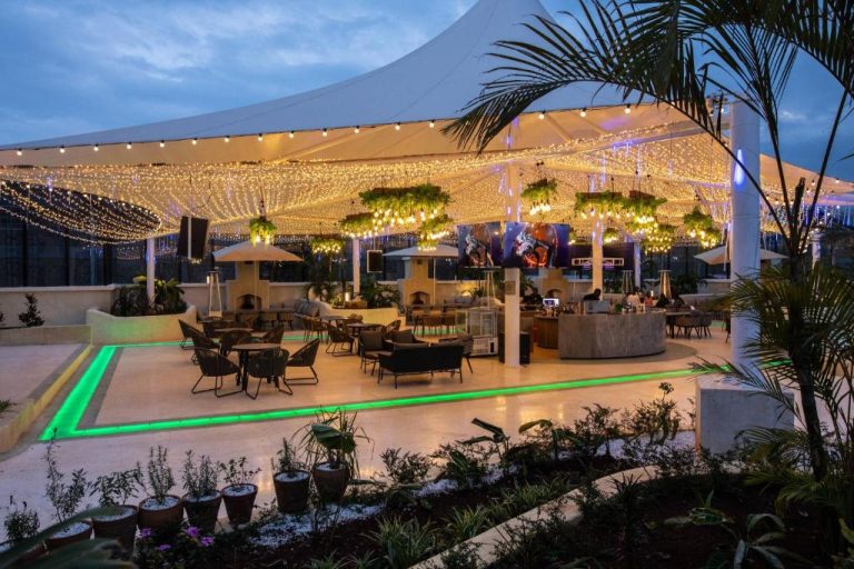 Terraza bar exterior con luces decorativas y zona lounge del Argyle Grand Hotel Nairobi Airport