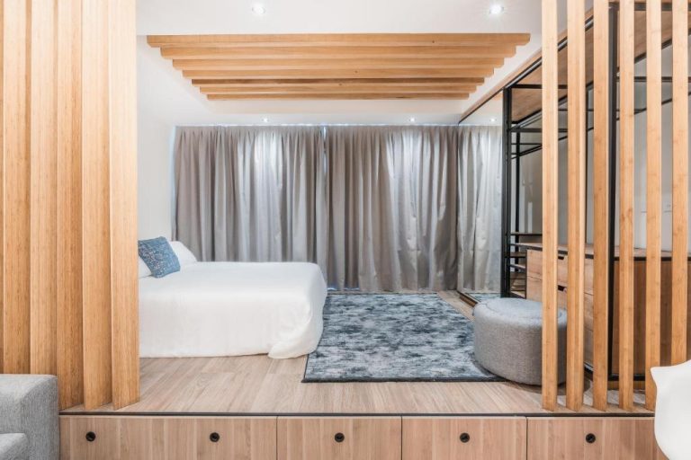 Habitación con cama doble, tarima de madera y listones decorativos en Hotel Faranda Single Punta Cana Adults Only