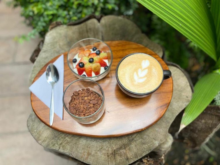Desayuno saludable con café latte art, yogur con frutas y granola en Beminimal Parques