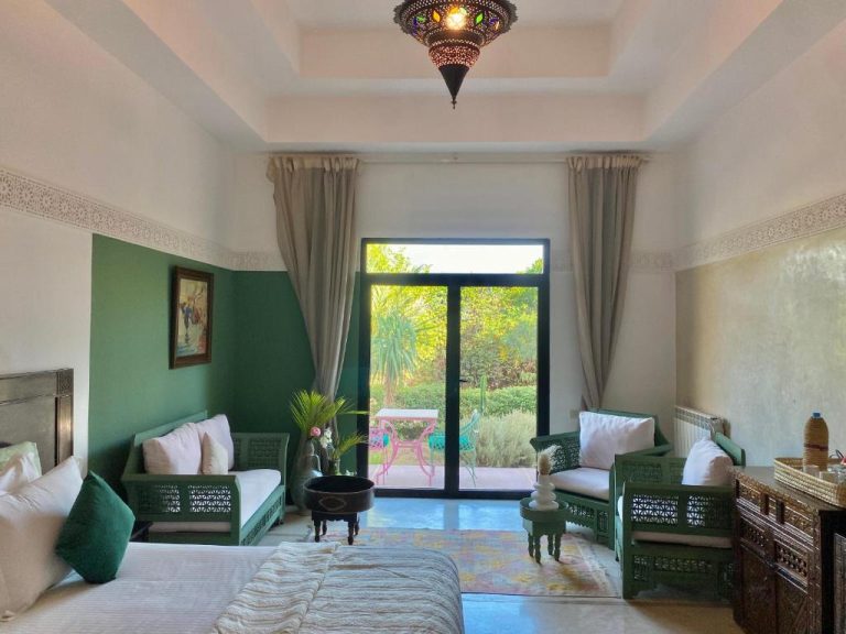 Habitación de estilo marroquí con muebles verdes tallados y vistas al jardín en La Villa Des Golfs & PinkCactus