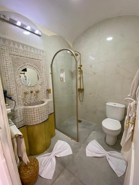Baño de lujo con ducha dorada y lavabo artesanal en La Villa Des Golfs & PinkCactus