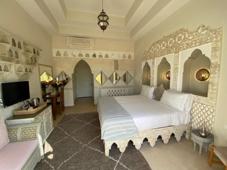 Habitación doble de estilo árabe con cama ornamentada y decoración marroquí en La Villa Des Golfs & PinkCactus