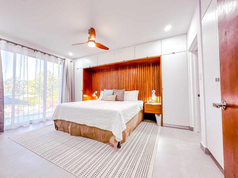 Habitación superior con cama doble y cabecero de madera en The Palms Resort con vistas al exterior