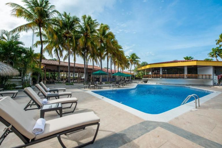 Piscina exterior con tumbonas y palmeras tropicales del Hotel Globales Camino Real Managua