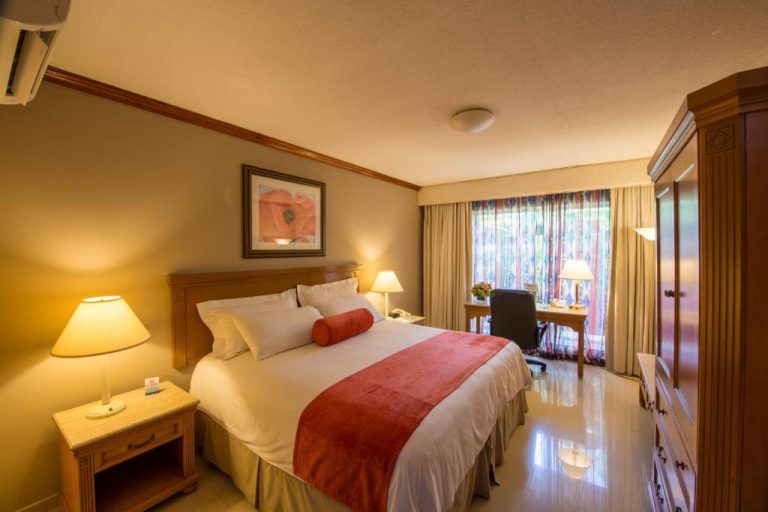 Habitación doble con cama king size y escritorio de trabajo en Hotel Globales Camino Real Managua