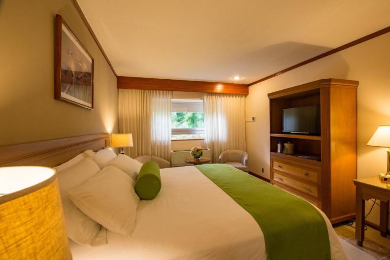 Habitación doble con cama king y decoración en tonos verdes del Hotel Globales Camino Real Managua