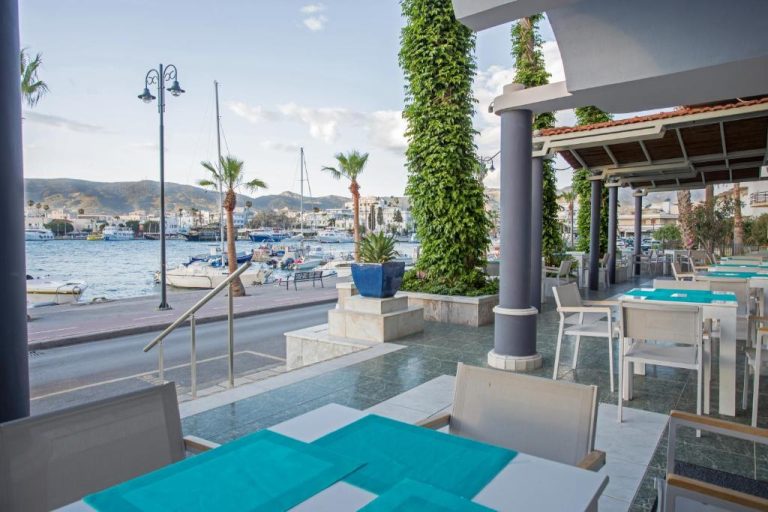 Terraza restaurante del Kosta Palace con vistas al puerto deportivo y barcos amarrados