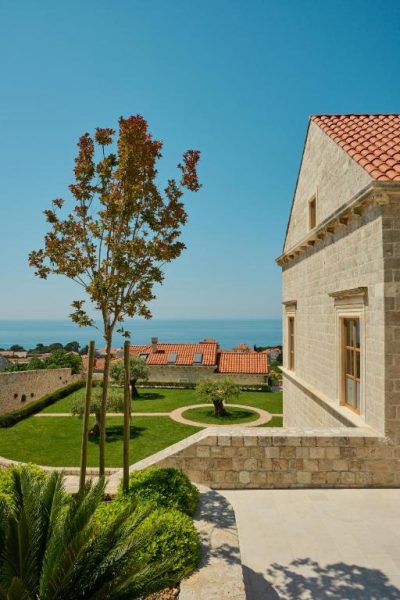 Jardín exterior con vistas al mar Adriático del Palace Natali, rodeado de arquitectura de piedra tradicional