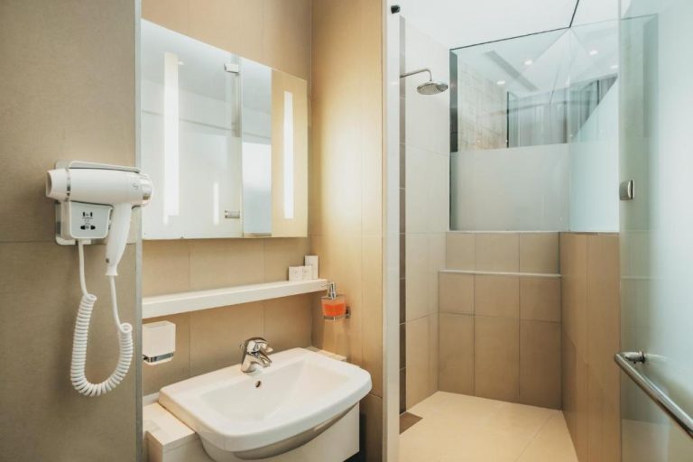 Baño moderno con ducha de cristal y secador de pelo en el Hotel Voila Bagatelle