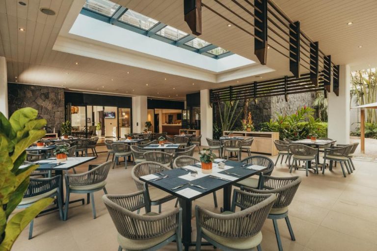 Restaurante con terraza interior y luz natural del Hotel Voila Bagatelle, con mesas y vegetación tropical