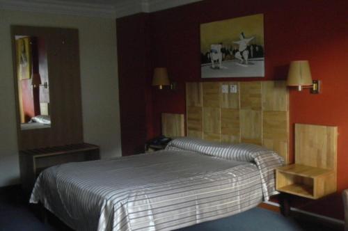 Habitación doble clásica con cama matrimonial y decoración en tonos rojos del Le Saint Georges Hotel