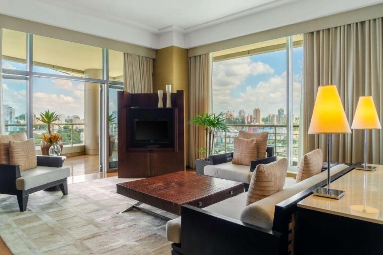 Amplio salón de suite con sofás, TV y vistas panorámicas a la ciudad en el Grand Hyatt São Paulo