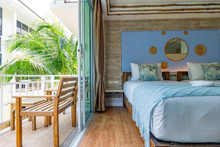 Habitación doble con decoración costera azul y balcón con vistas a palmeras en ARKbar Beach Club & Resort