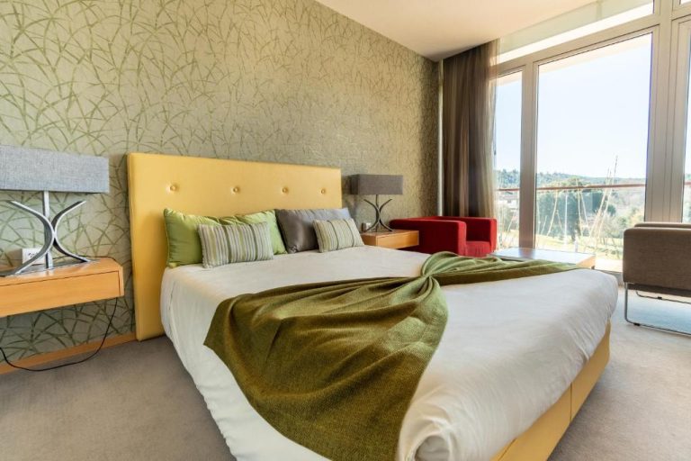 Habitación doble con cabecero amarillo y vistas al exterior en Hotel Santa Margarida