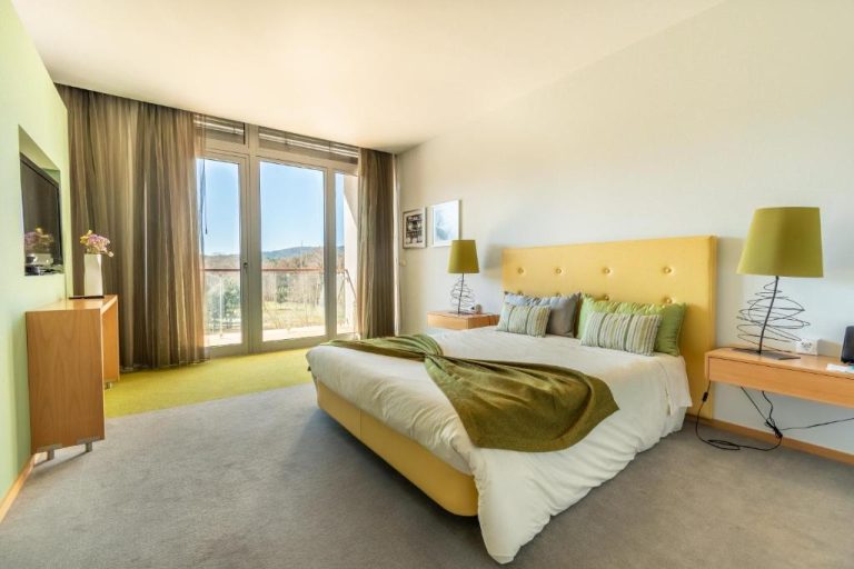 Habitación doble con cabecero amarillo y vistas al exterior en Hotel Santa Margarida