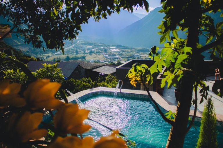 Piscina termal con chorro de agua y vistas panorámicas a la montaña en Spa Hotel Etelvina
