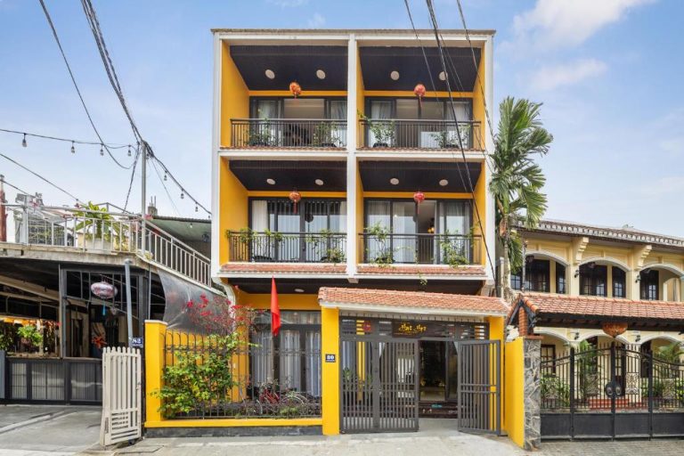 Fachada exterior amarilla con balcones y decoración tradicional del Hai Hội Villa Hoi An