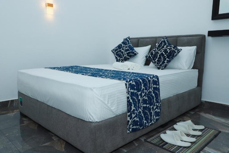 Habitación doble con cama king size y decoración azul en Airport Colombo Pocket Paradise