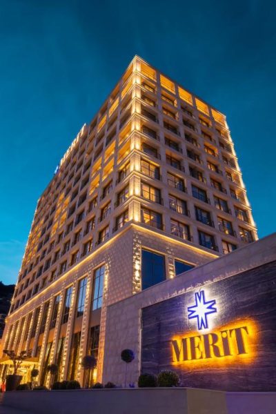 Fachada exterior iluminada del Merit Starlit Hotel & Residences al atardecer con arquitectura moderna