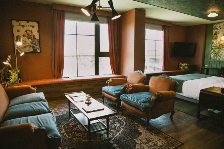 Suite con salón de estilo vintage y sillones de terciopelo azul en Hotel Eco Boutique Bidasoa