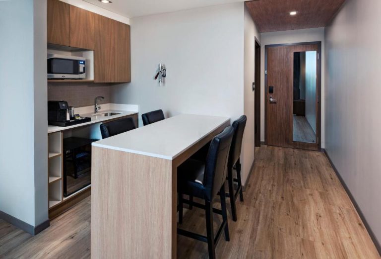 Kitchenette con barra de desayuno y sillas altas en AC Hotel by Marriott San Jose Escazu