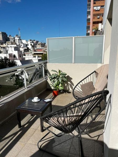 Terraza con sillas y mesa del Awwa Suites & Spa con vistas panorámicas a la ciudad