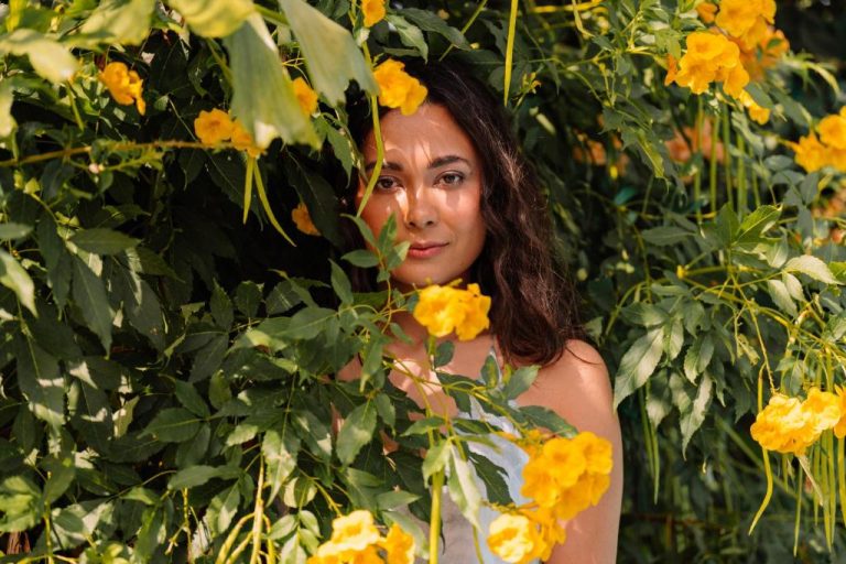 Mujer entre exuberantes jardines con flores amarillas en Paradera Park Aruba