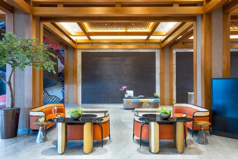 Elegante lobby lounge del hotel Morazen Yogyakarta con sillones naranjas y mesas de mármol negro