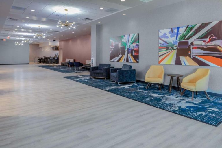 Amplio lobby del Hampton Inn & Suites Indianapolis West Speedway con arte temático de carreras de Fórmula 1