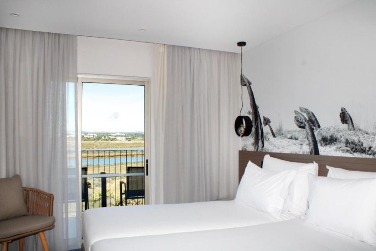 Habitación doble con cama blanca y vistas al estuario en AP Cabanas Beach & Nature Adults Friendly